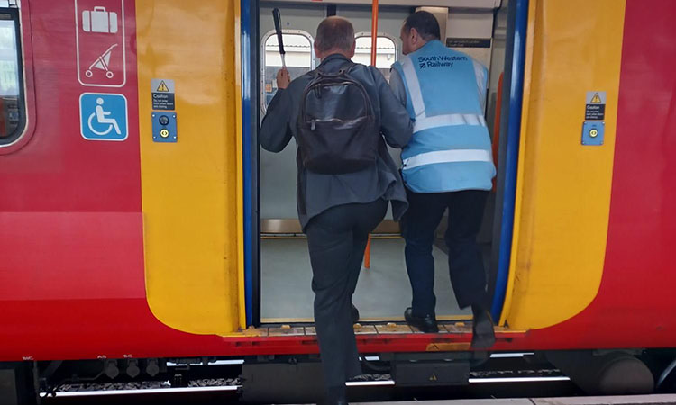 Blind man walking onto a SWR train