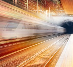 stylised image of a train travelling through a tunnel, featuring warm colours that indicate the dawn of a new day