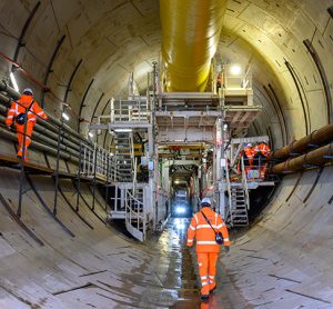 Site workers walking towards the TBM inside the north portal tunnel,