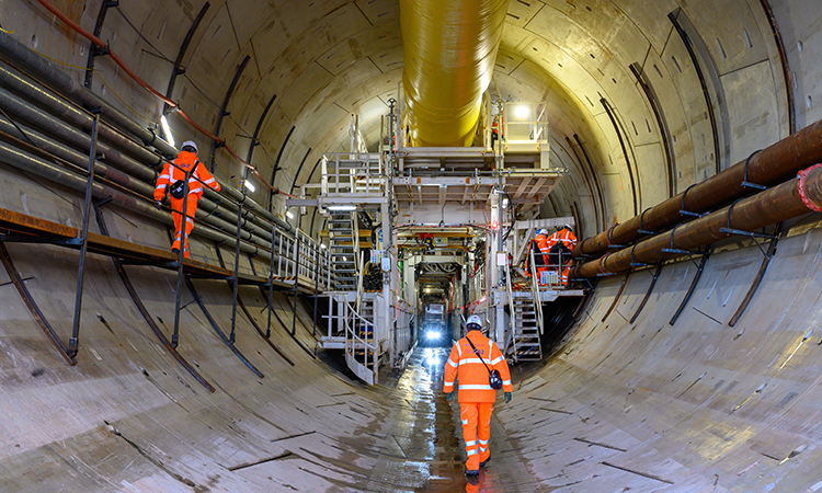 Site workers walking towards the TBM inside the north portal tunnel,