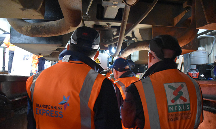 Industry colleagues looking underneath the train at the new technology