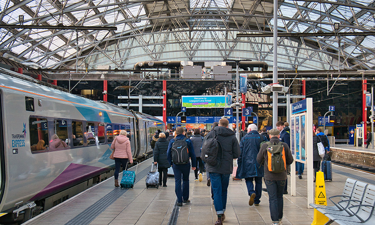 Liverpool station with passengers walking toward a train during November 2021