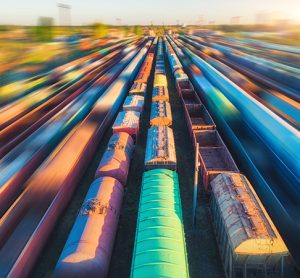 Aerial view of colorful freight trains at sunset.