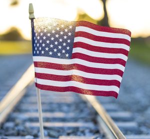 A closeup shot of the flag of the USA on the train rails