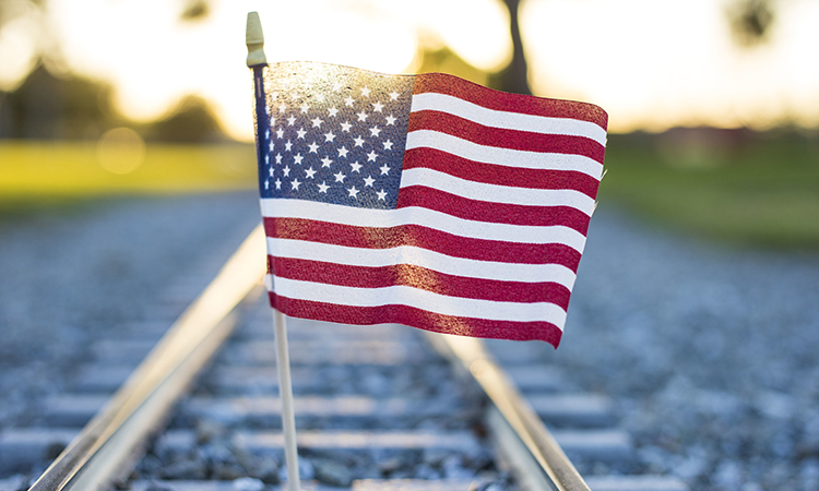 A closeup shot of the flag of the USA on the train rails