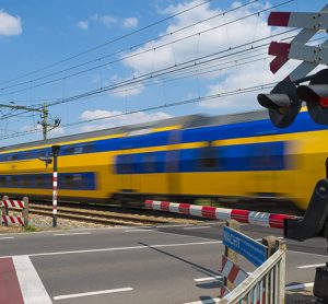 Train riding over a railway crossing in spring