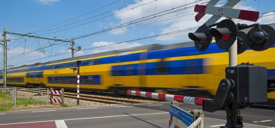 Train riding over a railway crossing in spring