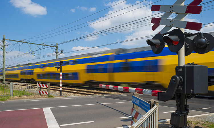 Train riding over a railway crossing in spring