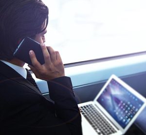 Businessman working with laptop on the way to work in train