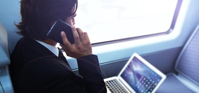 Businessman working with laptop on the way to work in train