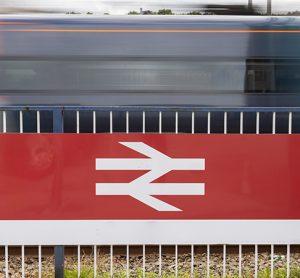 Tran passing a British rail logo with motion blur.