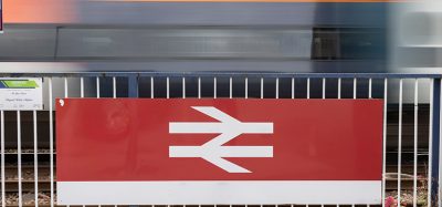 Tran passing a British rail logo with motion blur.