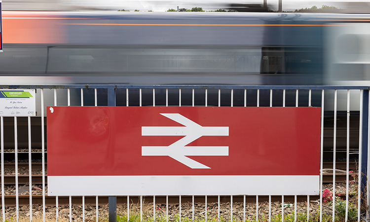 Tran passing a British rail logo with motion blur.