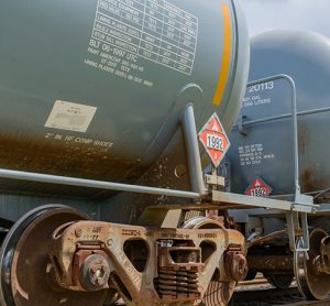 Two railroad tank cars displaying flammable hazardous materials signs