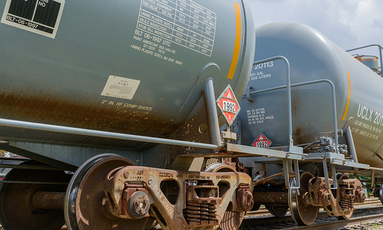 Two railroad tank cars displaying flammable hazardous materials signs