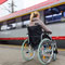 Young woman sitting in a wheelchair at a train station