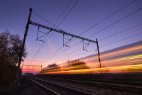 Passenger train on railroad tracks at the sunrise - blurred motion