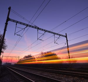 Passenger train on railroad tracks at the sunrise - blurred motion
