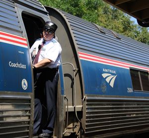 Railroad conductor on an Amtrak passenger train at Deland Railroad station in Florida.