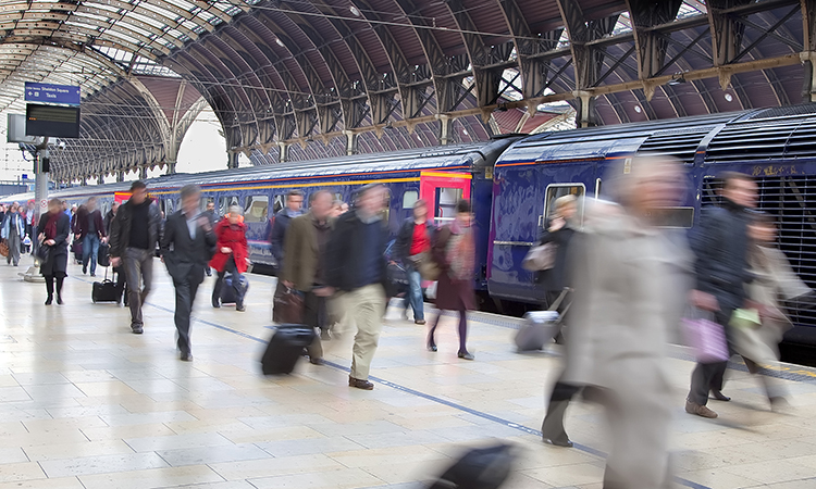 Commuters at Paddington station blurred with slow shutter speed, with all logos removed and all faces blurred beyond recognition.